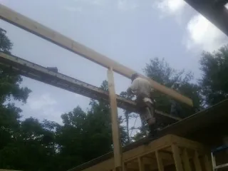 Carpenter setting a ridge beam over a new addition frame — Ice Dam Removal by Roofing Brothers in Blomkest