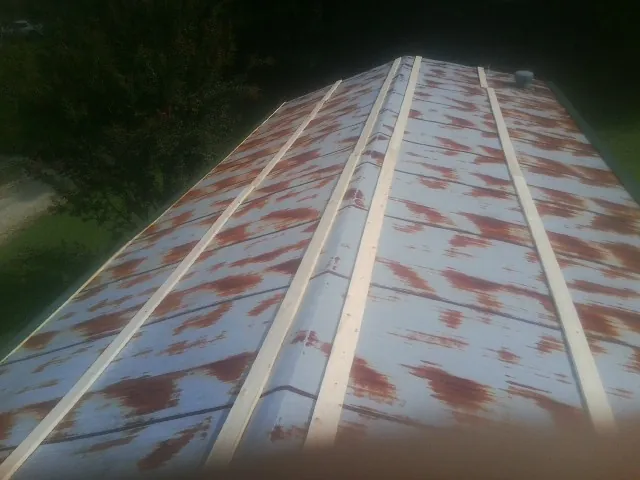 Rusted metal roof panels with new wood purlins before replacement — Storm Damage Roof Repair in Blomkest by Roofing Brothers