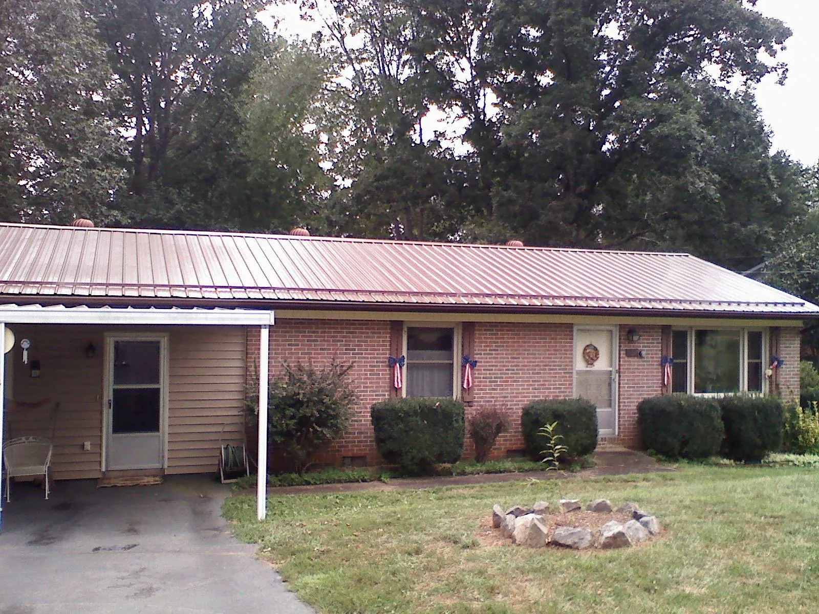 Bronze metal roof and carport on a brick ranch home — Roof Repair work by our crew in Blomkest